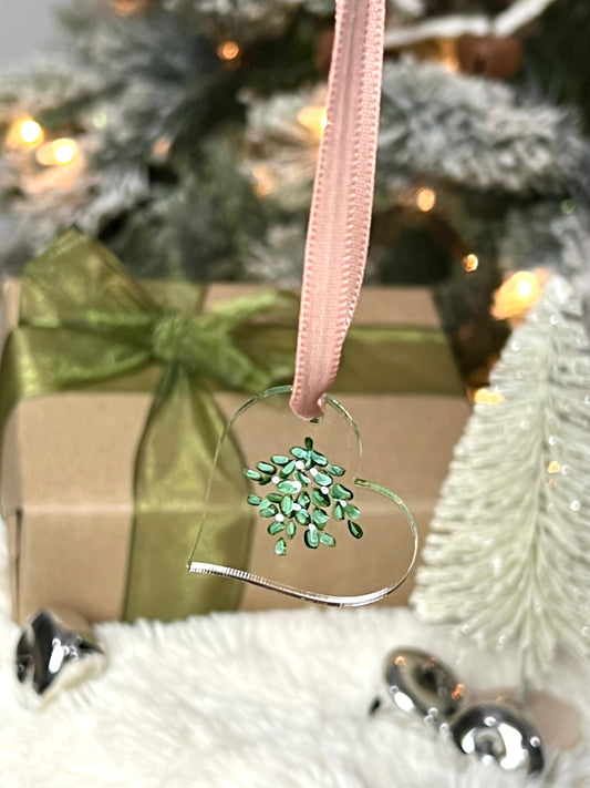 Clear acrylic heart ornament with hand painted mistletoe and a pink ribbon
