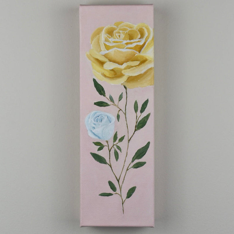 A hand-painted canvas artwork featuring a yellow rose and a blue rosebud on a pale pink background.