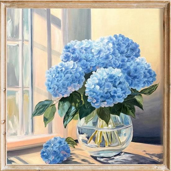 Framed artwork of blue hydrangeas in a glass vase on a windowsill.