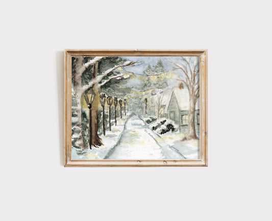 Framed winter landscape painting with trees and a house on a white wall