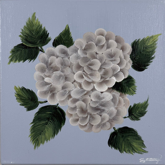 A square canvas painting of white hydrangea flowers with green leaves on a light blue background, mounted on a textured beige wall.