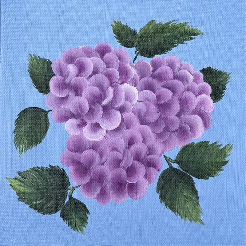A square canvas painting featuring a cluster of purple hydrangea blossoms with green leaves on a light blue background, displayed against a textured beige linen backdrop.