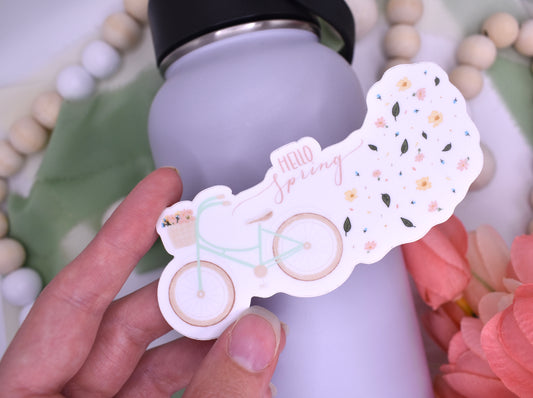 Spring sticker with a bicycle and flowers and the words "hello Spring" held over a water bottle