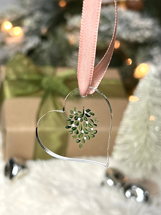 Clear acrylic heart ornament with hand painted mistletoe and a pink ribbon